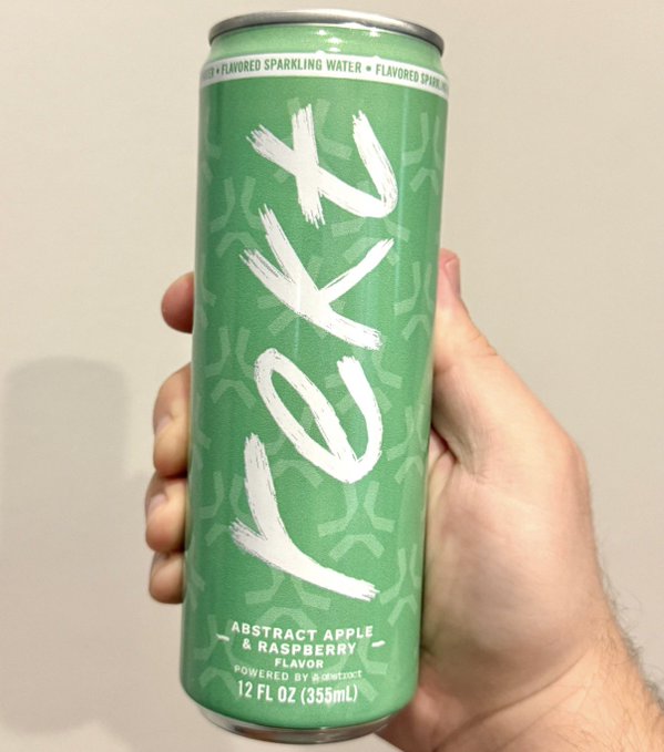 A hand holds a green beverage can branded 'LXOX' with large brushstroke-style lettering, labeled 'FLAVORED SPARKLING WATER' and 'ABSTRACT APPLE & RASPBERRY FLAVOR' at 12 FL OZ (355mL).