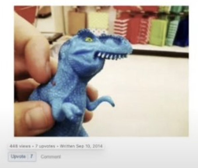 A hand holds a small blue toy dinosaur (resembling a raptor) in what appears to be a retail store; the post shows 448 views, 7 upvotes, and was written Sep 10, 2014.