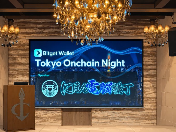 A presentation stage featuring a large screen displaying 'Bitget Wallet Tokyo Onchain Night' with Japanese text and a Tokyo Tower graphic, set against an elegant room with a chandelier and a podium with an anchor design.