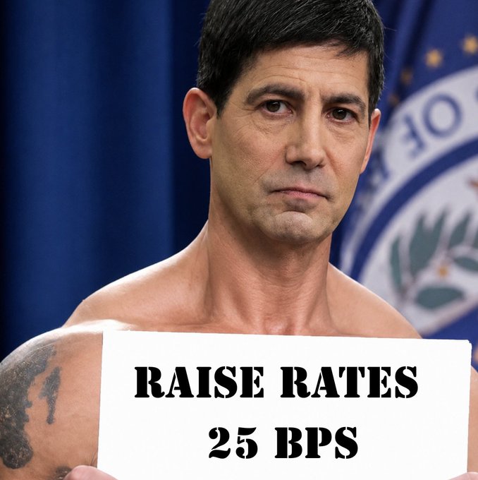 A shirtless man holding a sign reading "RAISE RATES 25 BPS" stands in front of a blue Federal Reserve backdrop, humorously impersonating a Fed official announcing the rate hike. The crude, makeshift sign parodies the formality of a central bank decision, matching the post's news that the Fed raised rates by 25 basis points for the first time since 2023.