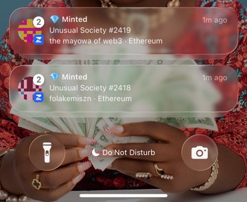 A smartphone screenshot showing iPhone notification banners indicating NFT mints: 'Unusual Society #2419 - the mayowa of web3 - Ethereum' and 'Unusual Society #2418 - folakemiszn - Ethereum', displayed over a background of hands counting cash.
