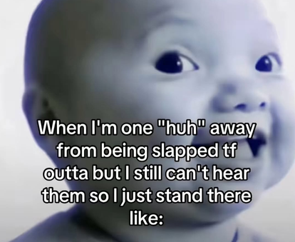 A black and white image of a baby with a wide-eyed, blank expression, overlaid with the text: "When I'm one 'huh' away from being slapped tf outta but I still can't hear them so I just stand there like:"