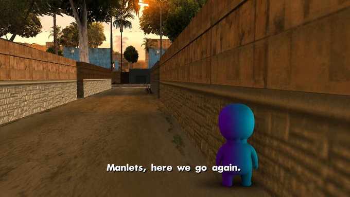 The image features a small blue figure standing alone on an empty street with a brick wall behind them. The text "Manels, here we go again" is written above the figure's head. The scene appears to be from a video game or animation, as indicated by the presence of the character and the surrounding environment.