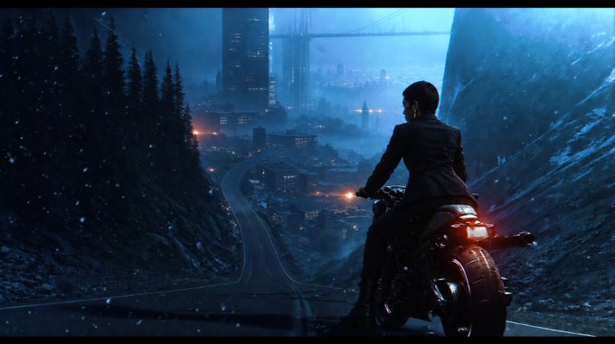 A cinematic, dark blue-toned scene showing a person in a dark suit riding a motorcycle on a road, looking out towards a distant, illuminated city nestled in a valley between snowy mountains.