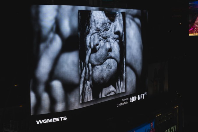A large outdoor digital billboard at night displays a black-and-white NFT artwork, credited to 'J.P. MoriStudio' with a '100 NFT' designation, above the 'WGMEETS' logo.