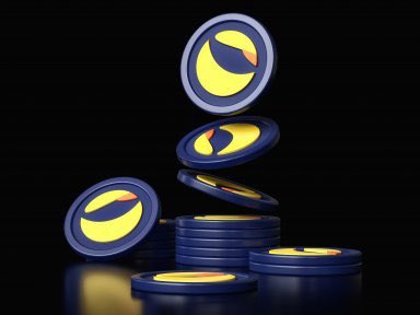 urn of blue and yellow coins, arranged in a pyramid shape against a black background.