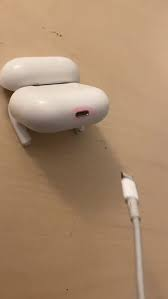In this image, a white electronic device, possibly an AirPods or a similar earbud, sits on a table with its power cord attached to it. The device appears to be turned off, indicating that no sound is currently playing or being played. There's also a quote below the device that says: "now that your favorite coin $MEGA is up 40% on the weekly you can start buying more just for it to start dumping again (you know you want to but at the same time you know it won't work out for you)".