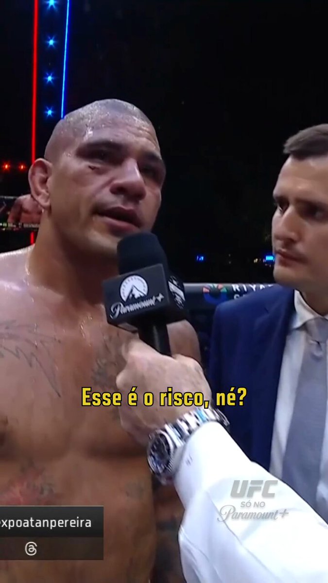 The image features a man with tattoos, who appears to be a fighter or wrestler, talking into a microphone during an interview. The man has his shirt off, revealing his tattooed arms. The background of the image shows a boxing ring setting, indicating that this might be related to a fight or wrestling event. The post includes text in Portuguese and English, which could be discussing the fighter's return from a match at the UFC White House.