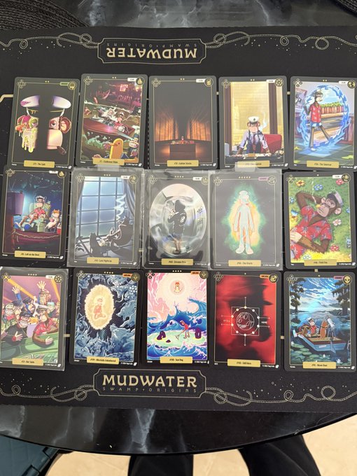A board game spread labeled “MUDWATER,” showing three rows of illustrated tarot-style cards with gold labels and ornamental line art.