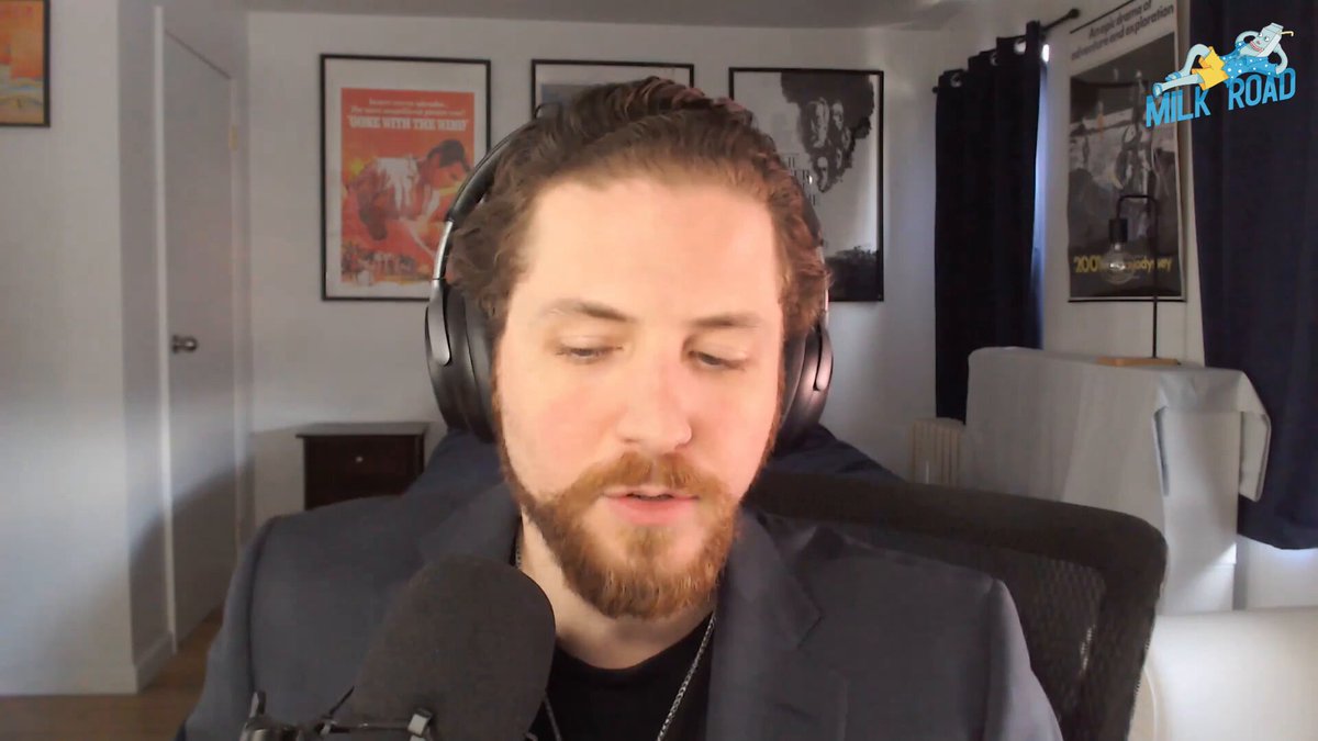 The image shows a man wearing headphones sitting at a desk, possibly working or listening to something interesting. The background features several posters hanging on the wall, which could be related to the content of the post about Ethereum's fundamentals. The focus should remain on the main subject - the man with the headphones and his surroundings.