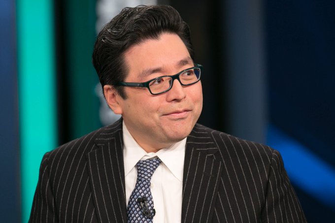 Tom Lee appears as a guest in a televised interview setting. The accompanying post highlights BitMine, chaired by Tom Lee, continuing its 58-week streak of Ethereum ($ETH) purchases, contrasted against Strategy's recent Bitcoin ($BTC) sell-off, positioning Lee's firm as a consistent crypto accumulator.