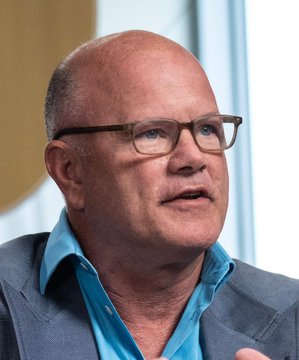 Mike Novogratz, shown here speaking, advocates for a fair ethical compromise between political parties regarding elected officials profiting from their office, emphasizing that both sides have room to negotiate.
