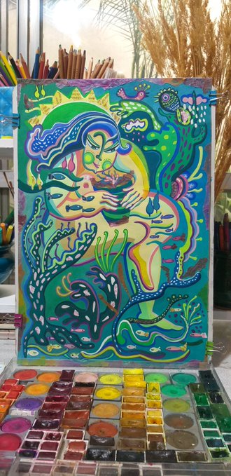A vibrant, psychedelic watercolor painting depicts a nurturing figure embracing a small Earth, surrounded by lush coral-like flora in neon greens, blues, and purples, perfectly echoing the caption's meditation on the realization of our inseparable connection to nature. The artwork sits atop a colorful watercolor palette, with pencils and dried grasses visible in the background of the artist's workspace.
