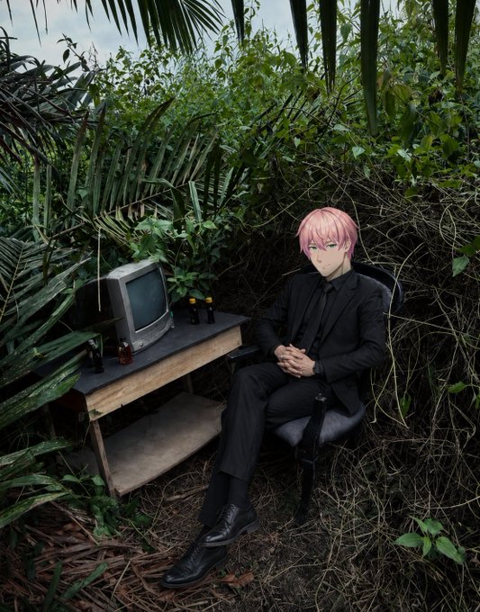 An anime-style character with pink hair and green eyes, dressed in a black suit, sits in a chair at a wooden desk with an old CRT monitor in a dense, jungle-like outdoor setting.