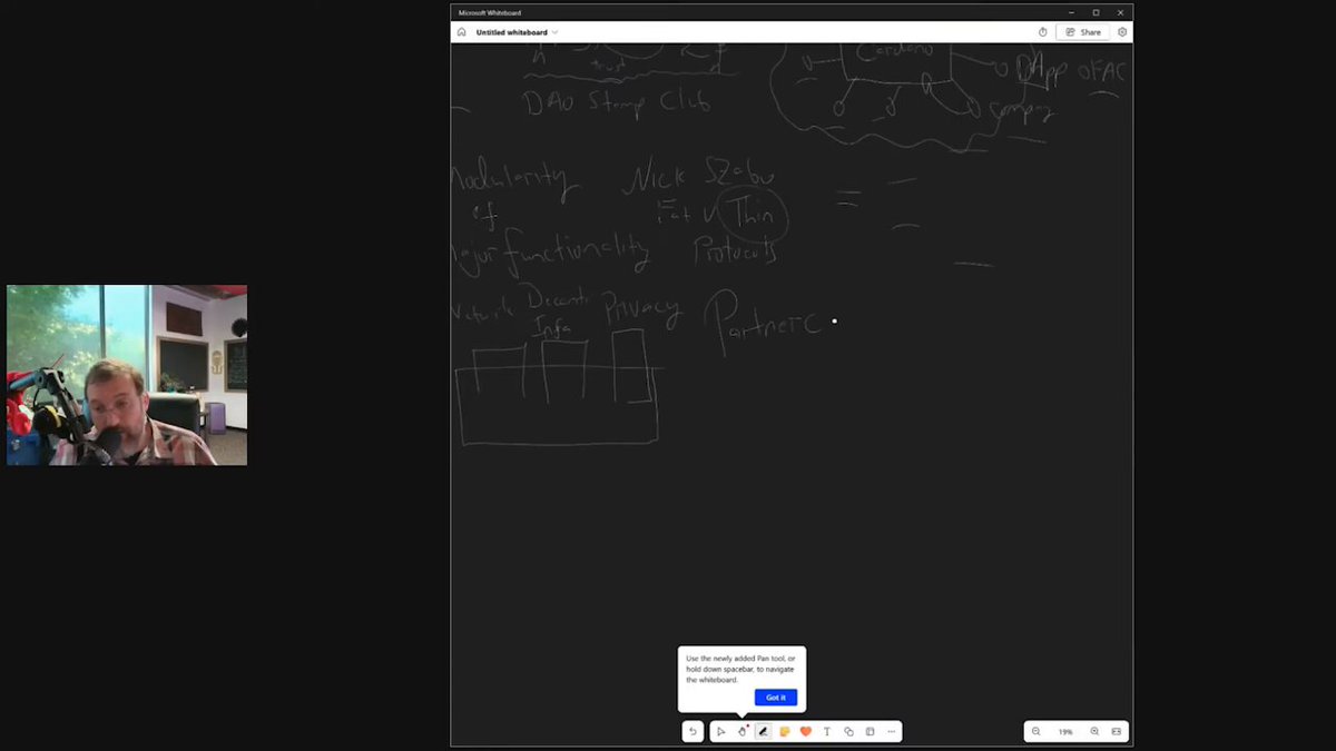 The image shows a computer screen with a black background, displaying a webpage or presentation related to cryptocurrency. The text on the screen reads "Cardano $ADA Founder Charles Hoskinson says Cardano has one settlement layer and many computation layers. When you plug in (a computing layer), you gain that capability across Cardano—keeping Cardano thin—allowing infinite expansion of functionality." This information is likely about the partnership between Cardano and another company, possibly Ripple, as described by Charles Hoskinson on his blog.