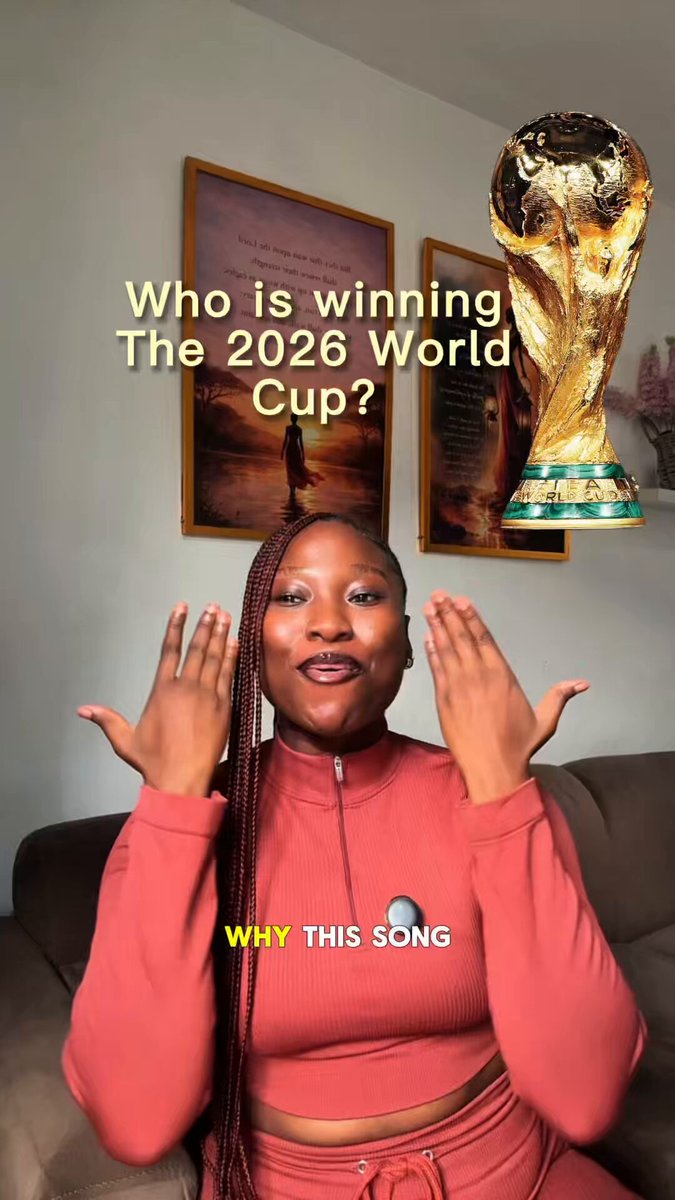 The image features a woman wearing a red top, sitting on a couch with her hands raised as if she's giving a speech or making a statement about the World Cup. The photo has been edited to include a caption that reads "Why This Song", which is likely related to the event taking place in the image.