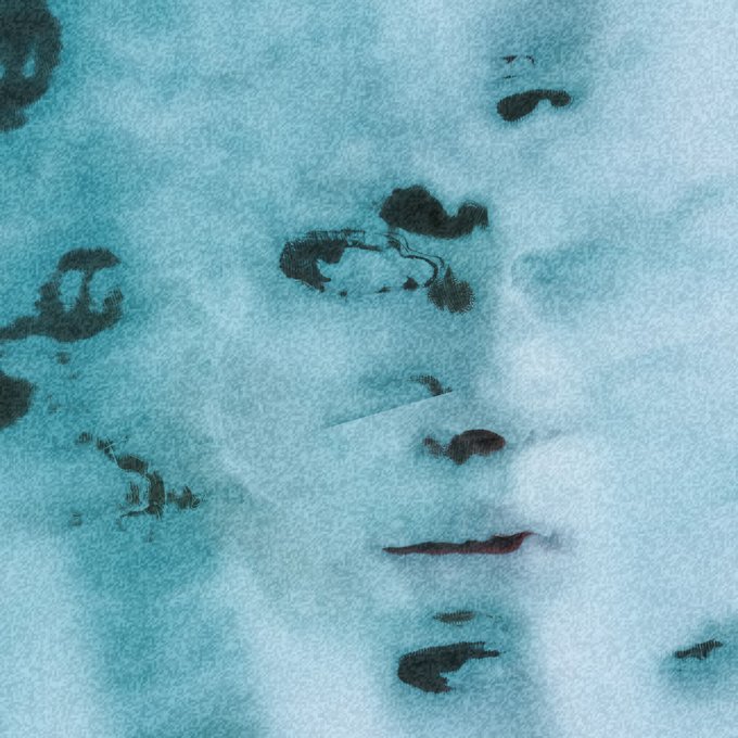 A heavily textured, blue-tinted artistic image appearing to show a person's face, possibly in water, with a dreamy or distorted visual effect.
