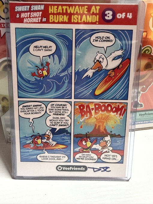 A VeeFriends trading card titled 'HEATWAVE AT BURN ISLAND! 3 of 4' featuring Sweet Swan and Hot Shot Hornet in a comic strip format showing the characters surfing and encountering a volcanic eruption on an island.