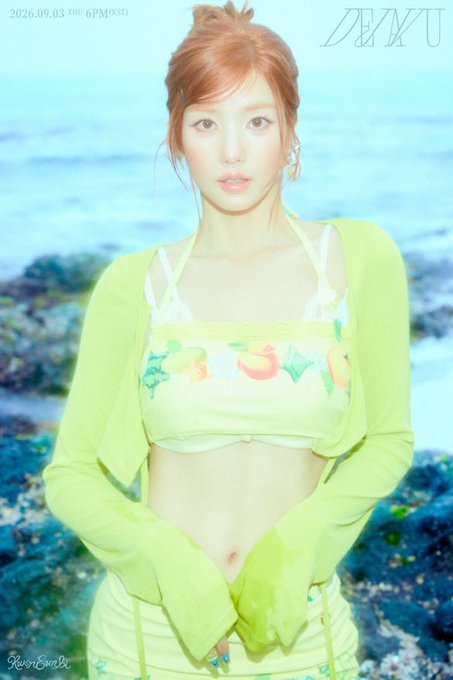 A woman with reddish-brown hair in a bun wears a yellow crop top with fruit designs and matching yellow pants, with text reading '2026.09.03 THU 6PM (KST)' and 'ZERU'.