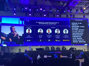 A conference stage with a large screen displaying a panel discussion titled 'AI AGENTS, INFRASTRUCTURE & ENTERPRISE ADOPTION' featuring multiple speakers and a translator section in Chinese; the 'N3' logo is visible.