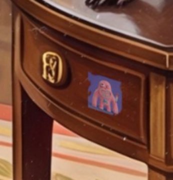 A close-up of a wooden nightstand featuring a gold 'NY' Yankees logo emblem and a blue sticker depicting a cartoon character.