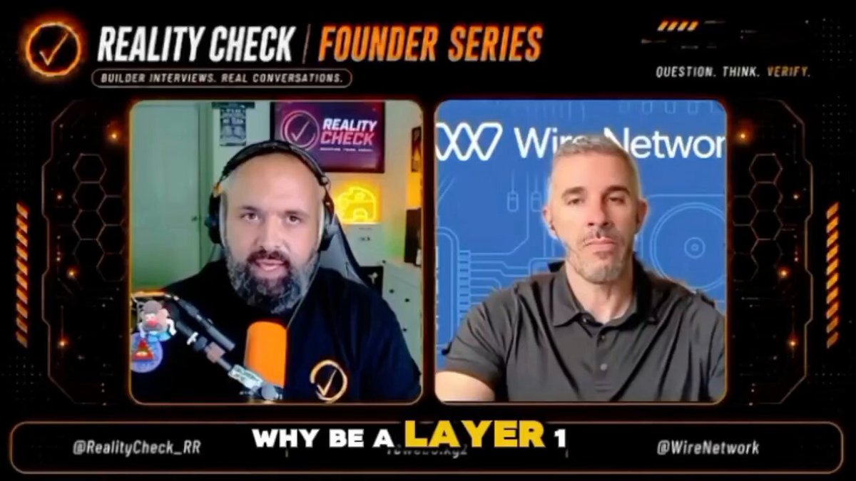 The image shows two men sitting behind a computer screen, with one man wearing headphones and holding an orange object while the other man has his hands resting on his lap. The background of the image features a logo for "Why be a Layer 1?".