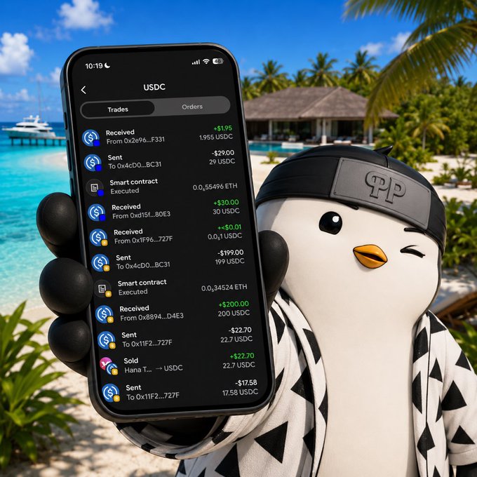 A penguin mascot wearing a black headband holds a smartphone displaying USDC cryptocurrency transaction history on a tropical beach.