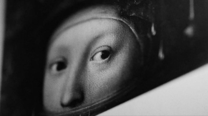 A black-and-white close-up photograph of a classical painting showing a face, likely the Mona Lisa, partially obscured.