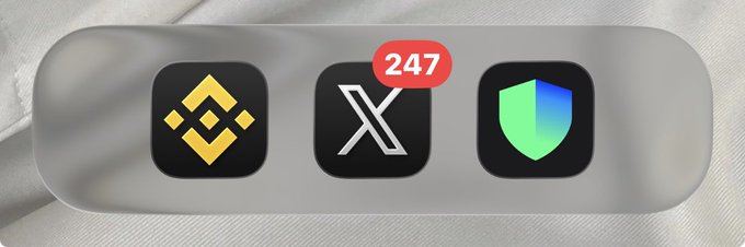 A widget on a white fabric background displays three app icons: Binance, X (with a notification badge showing 247), and what appears to be a green shield app.