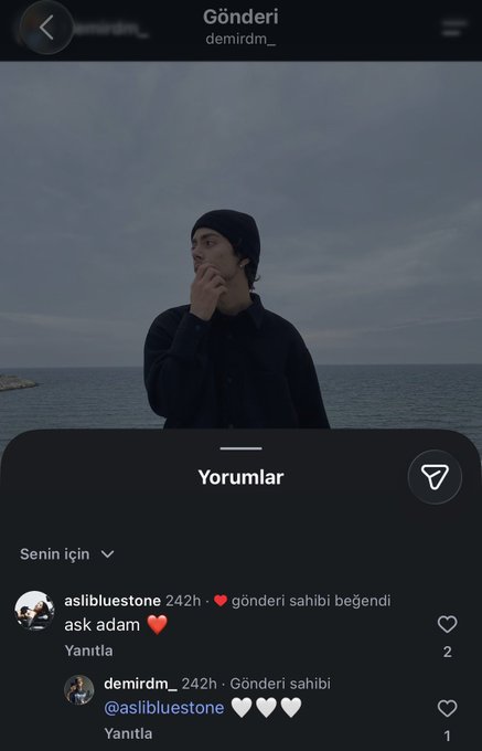 An Instagram post screenshot by user 'demirdm_' featuring a moody photo of a man by the sea, with a comment section visible below.