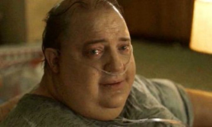 Actor Brendan Fraser in heavy prosthetics, appearing emotional with tears and an oxygen tube in his nose, likely from the film 'The Whale'.