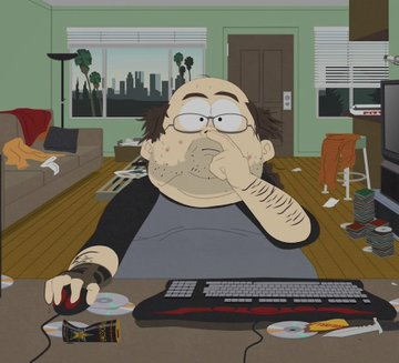 An animated scene of a man with a stubbly beard sitting at a messy desk with a computer, keyboard, mouse, and stacks of CDs, appearing bored or tired.