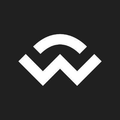 The image features a logo with a white "W" shape, which appears to be a symbol or design element. The background of the image is black, making the white "W" stand out prominently. There are no other objects or texts present in the image. The focus on this particular logo and its context suggests that it might be related to a specific event or announcement about Solana's new integration for crypto payments.