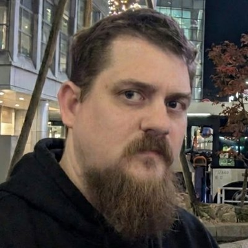 The image features a man with a beard wearing a black hoodie, standing outside of a building at night. He has his eyes closed and appears to be posing for a photo or selfie. The caption "Fake but Funny Pump it #KAS" is written below the image, which seems to be related to the post that includes this picture.