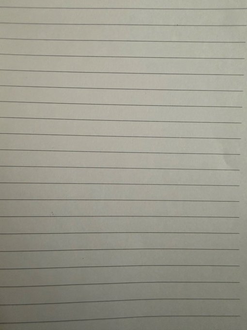 A blank piece of lined notebook paper photographed at a slight angle.