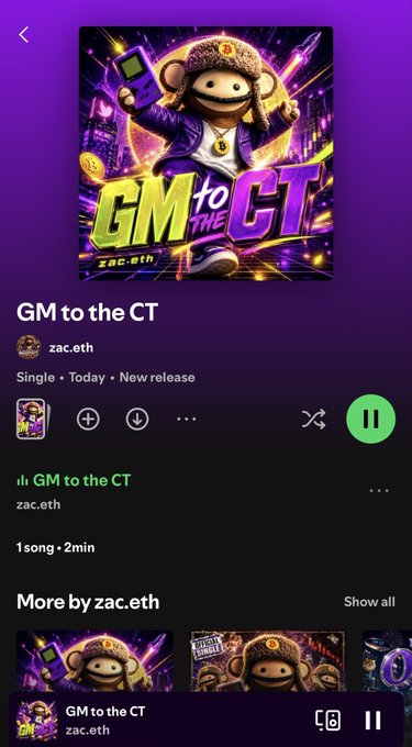 A Spotify mobile app screenshot showing the single "GM to the CT" by zac.eth, now streaming as a new release, with the album artwork featuring a cartoon monkey character wearing a beanie, sunglasses, and a gold chain while holding a smartphone. The interface displays playback controls, indicating the track is currently playing, matching the post's announcement of the track's release.
