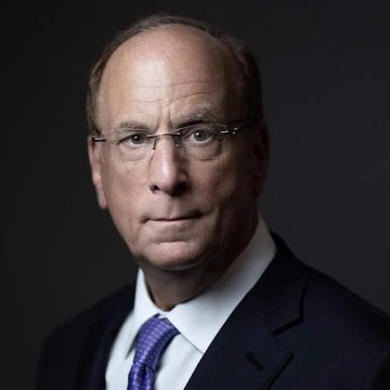 The image features a man dressed in a suit wearing glasses and a tie with a purple pattern. He has an expressionless face looking off into the distance. The caption provided after the picture reads that "MASSIVE: BlackRock says we're at the beginning of the tokenization of ALL assets as DTCC brings tokenized securities worth over