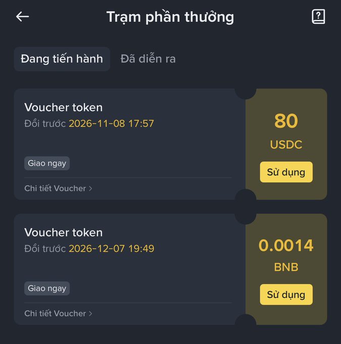 A Vietnamese-language cryptocurrency rewards interface ("Trạm phần thưởng") displays two token vouchers: 80 USDC expiring 2026-11-08 and 0.0014 BNB expiring 2026-12-07, each with a yellow "Sử dụng" (Use) button.