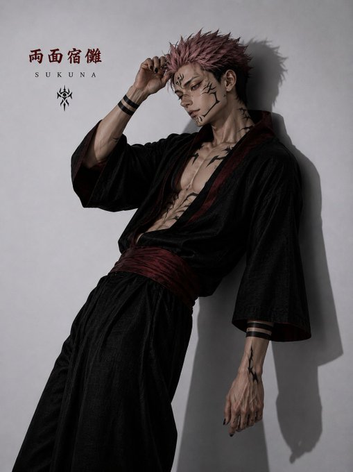 A cosplayer dressed as Sukuna from Jujutsu Kaisen stands in a kimono with the Japanese characters "両面宿儺" (Ryomen Sukuna) and "SUKUNA" displayed on the wall beside him, though the image appears unrelated to the post's text about $ANSEM trending and the community rallying around @blknoiz06.

My caption: This image seems disconnected from the post's content—instead of crypto-related memes or charts, it features a cosplay of Sukuna from Jujutsu Kaisen with his name in Japanese (両面宿儂 SUKUNA), which doesn't tie into the $ANSEM hype or community rallying mentioned in the text.