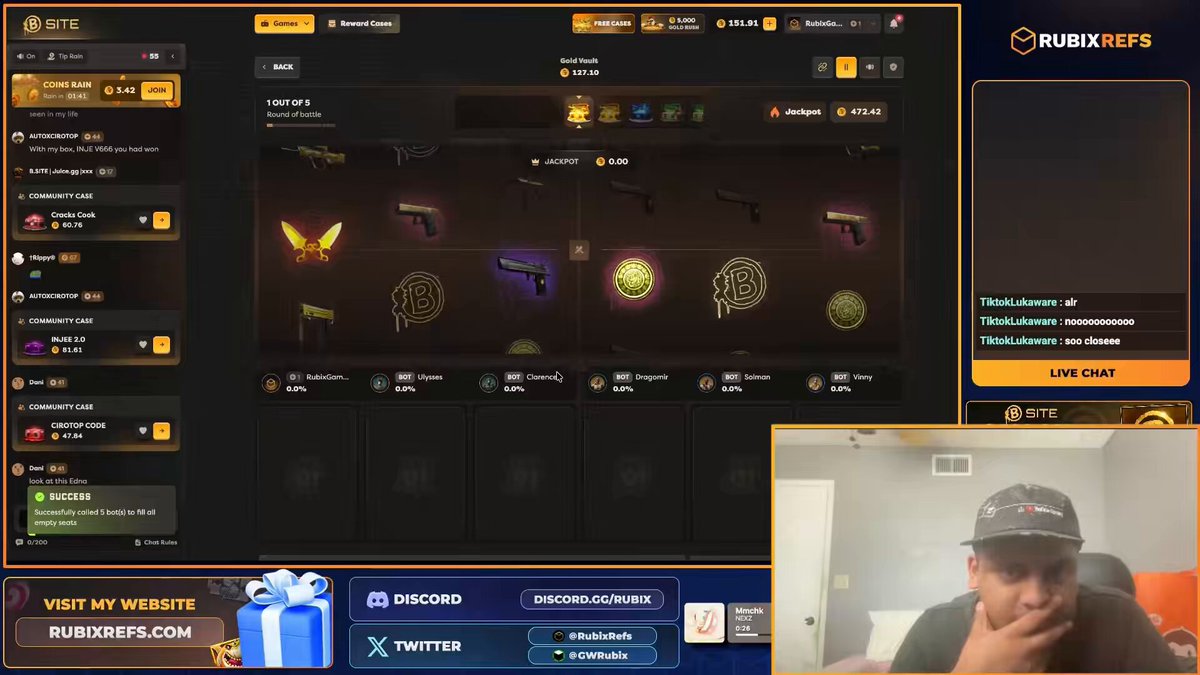 The image shows a RubixRefs game interface with a man sitting in front of it, likely playing the game. The game has a black background with various items displayed on the screen, including a sword, a gun, and other game elements. A chat window is also present, suggesting that players can communicate with each other during gameplay.

The post about the giveaway features two winners who have posted their names in the comment section below the image. The first winner has won 500 coins, while the second one has won 250 coins. Both winners are reposting on rubixrefs.com to share their experiences and encourage others to join the game.