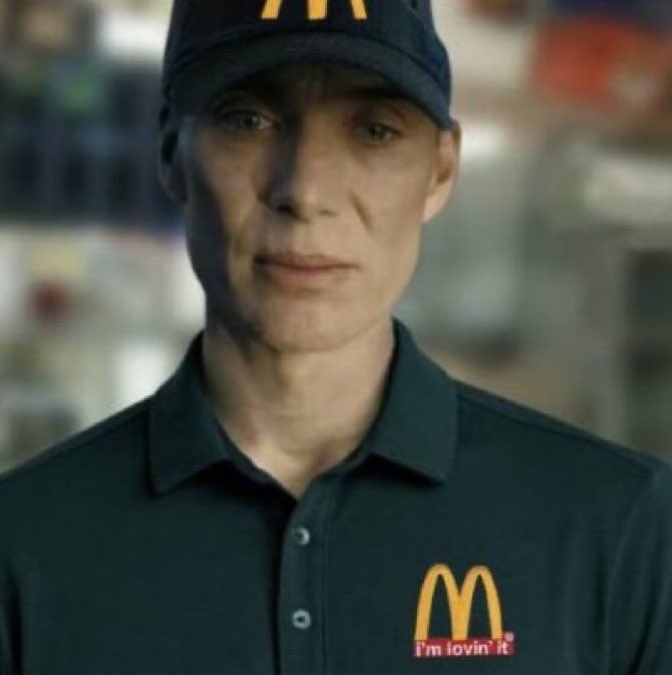 A man in a dark green polo shirt and matching cap with a McDonald's logo and 'I'm lovin' it' text.