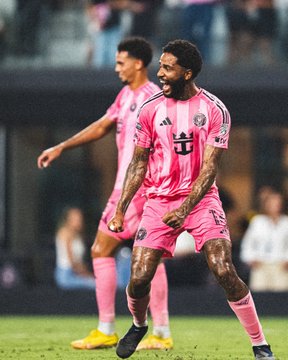 A player in Inter Miami's distinctive pink jersey celebrates intensely with clenched fists and an open-mouthed shout on the pitch, with a teammate visible in the background. The scene likely depicts a moment of triumph for the team, reinforcing the post's confidence in Inter Miami's 56% probability of victory over Rayados in the LeaguesCup according to Polymarket.