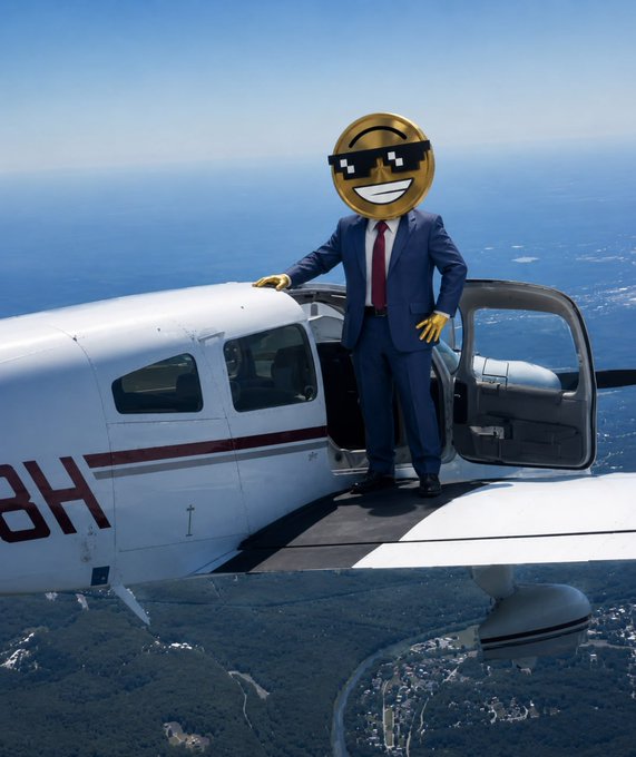 A figure in a blue business suit with a smiling emoji wearing pixelated sunglasses for a head stands on the wing of a small airplane flying over a coastal landscape.