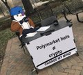 A person wearing a blue winter hat stands behind a white street sign that reads 'Polymarket bets' with a QR code visible.