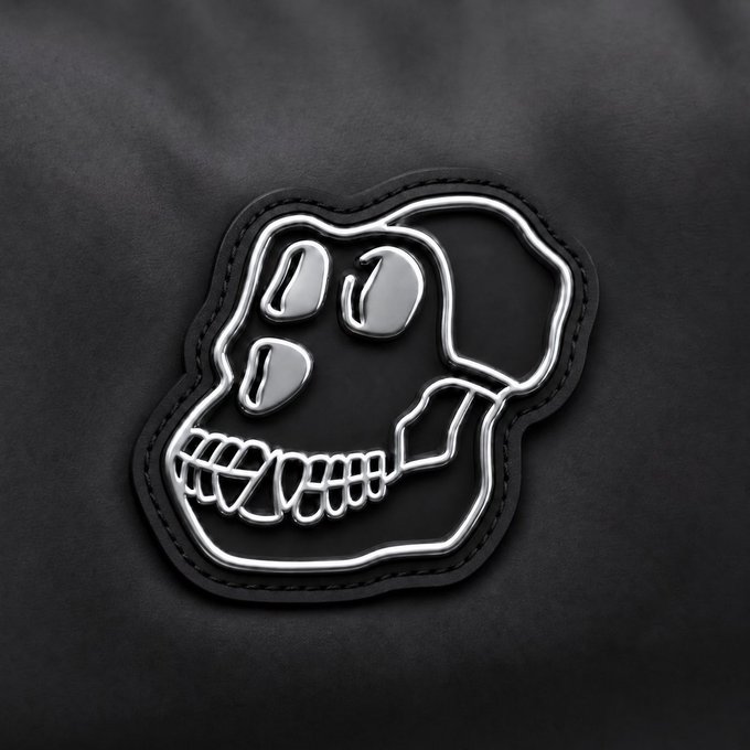 A chrome skull emblem is stitched onto a black leather patch, evoking a rugged, edgy aesthetic that complements the post's rugged yet rebellious spirit. The skull's metallic shine contrasts sharply with the dark leather, aligning with the "Built from Titanium" theme while adding a gritty, degens-inspired flair to the Bored Ape reference.
