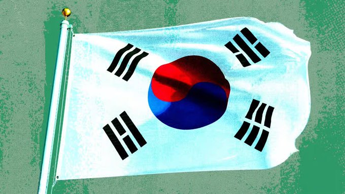 The South Korean national flag (Taegeukgi) waving against a green background.