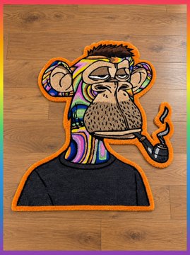 A colorful embroidered patch featuring a stylized Bored Ape character with a cigar, displayed against a wooden background with a rainbow border.