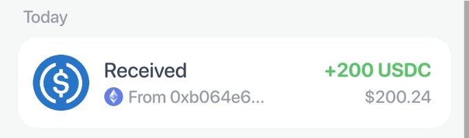 A crypto wallet notification showing a received payment of +200 USDC (approximately $200.24) today from the address starting with "0xb064e6...". The image illustrates the poster's caption about checking their wallet and finding an unexpected $200 windfall, likely from a web3 airdrop or transfer.
