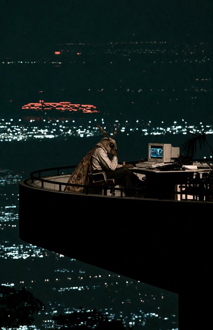 A cinematic image of a person in a deer head mask sitting at a desk with a computer monitor, positioned on a circular platform overlooking a sprawling, illuminated cityscape at night.