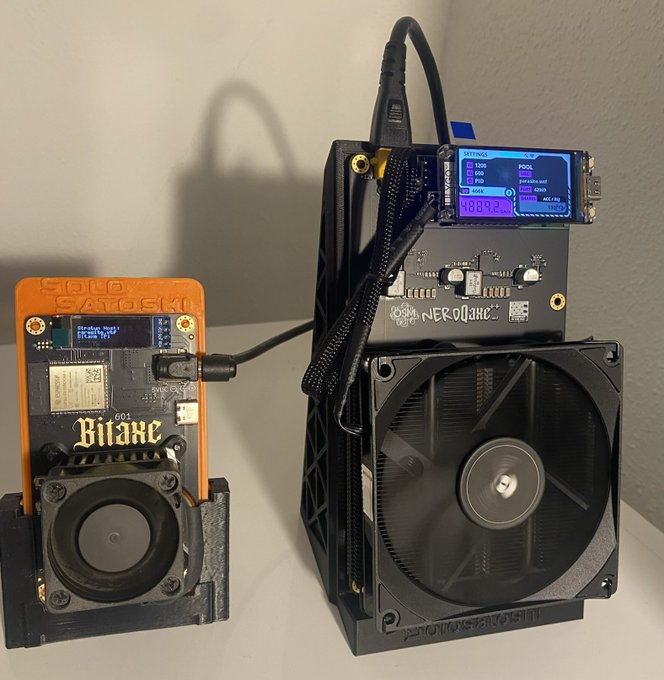 Two cryptocurrency mining devices sit side by side: a Solo Satoshi 'Bitaxe' on the left and a larger Nerds IQC ASIC miner on the right, both with cooling fans.